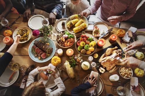 Table surrounded by people enjoying a harvest meal